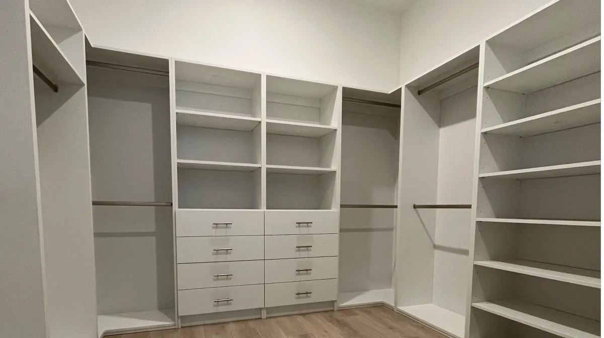 Custom walk-in closet with premium shelving and backing panels by EG Contractors in Naples, FL