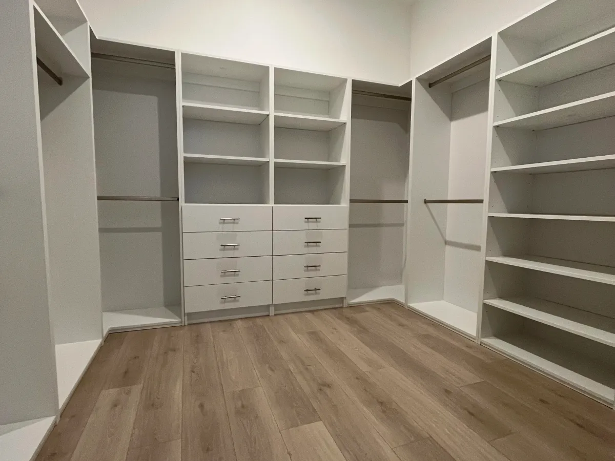 Custom walk-in closet with full backing panels and soft-close drawers in Naples, FL