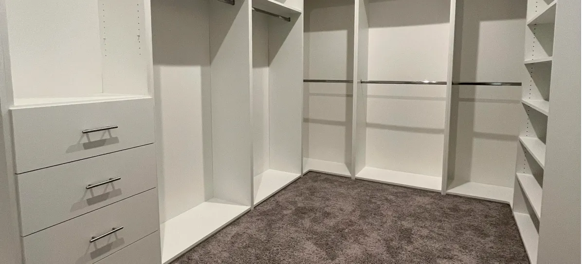 Custom walk-in closet with island and shoe racks by EG Contractors in Naples, FL