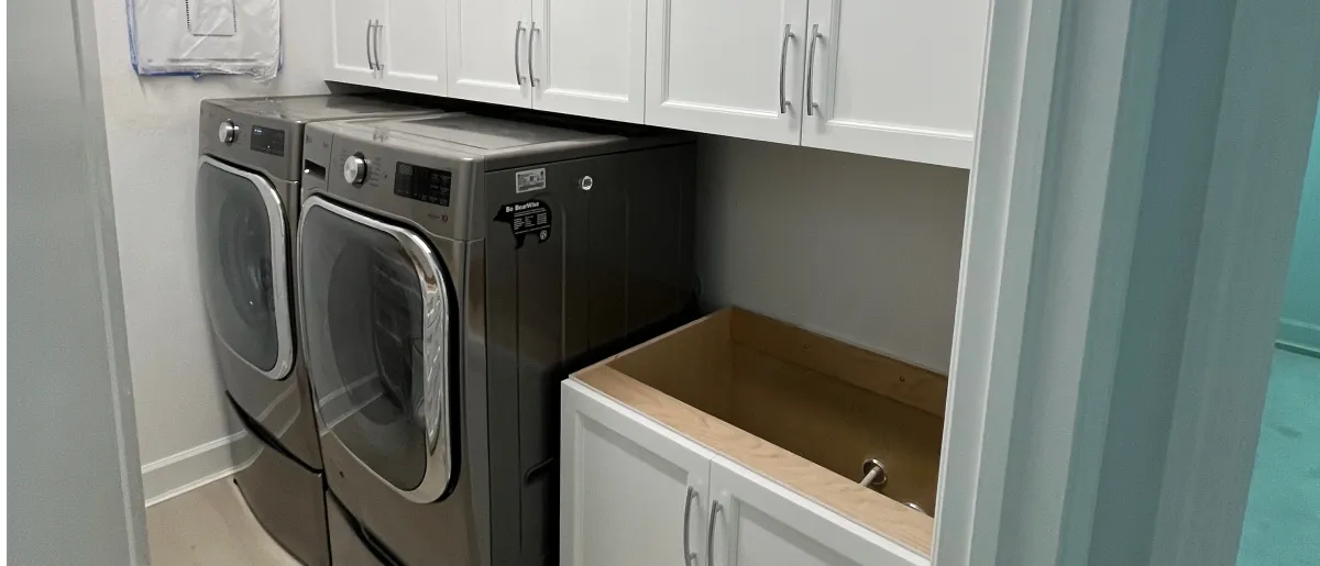 Custom laundry room cabinets with folding counter by EG Contractors in Naples, FL
